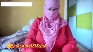 فتاة عربية مسلمة ترتدي حجابًا برتقاليًا تتباهى بثدييها الضخمين على الكاميرا